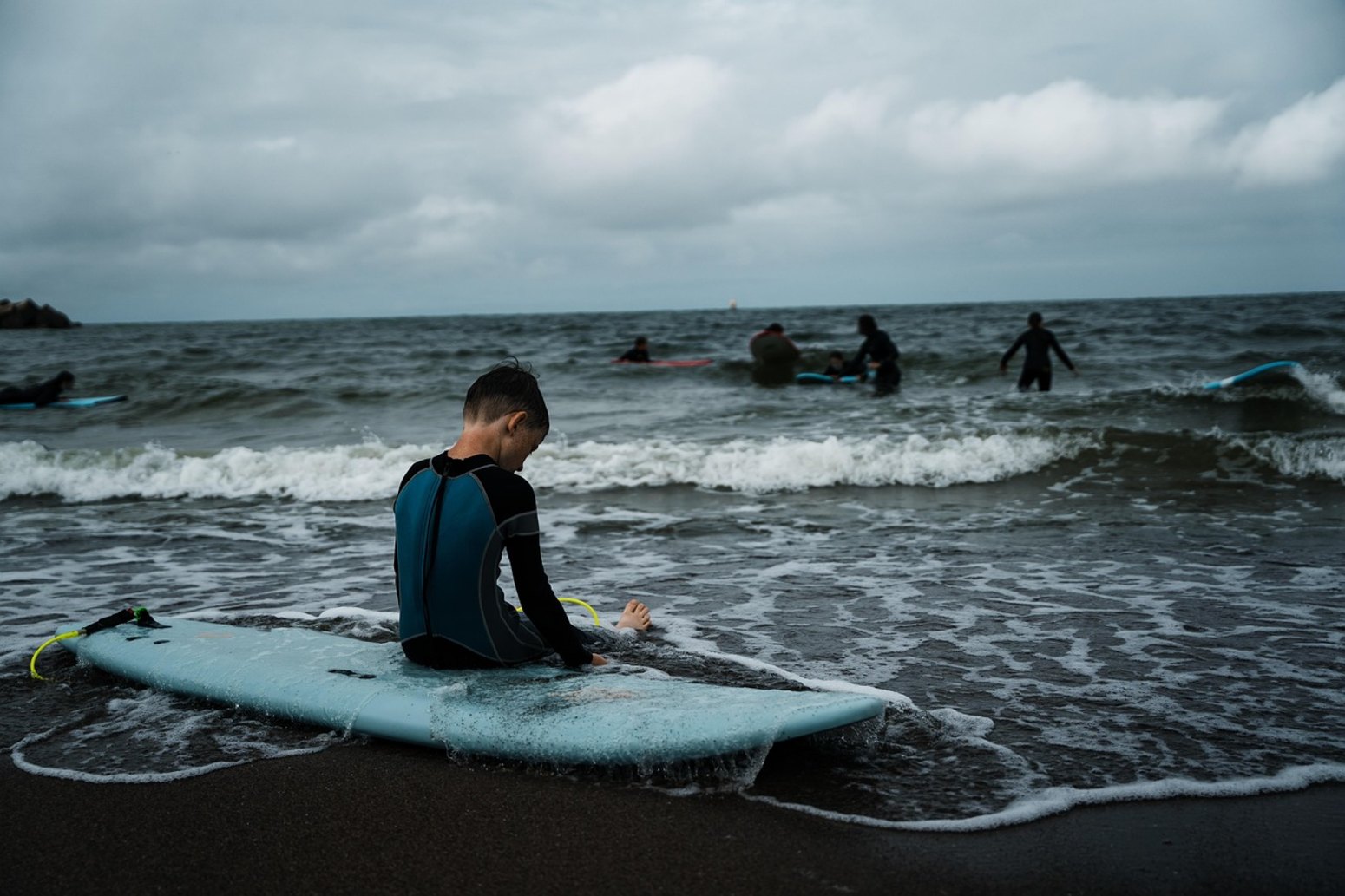 Niño aprendiendo surf, vacaciones monoparentales en Matalascañas