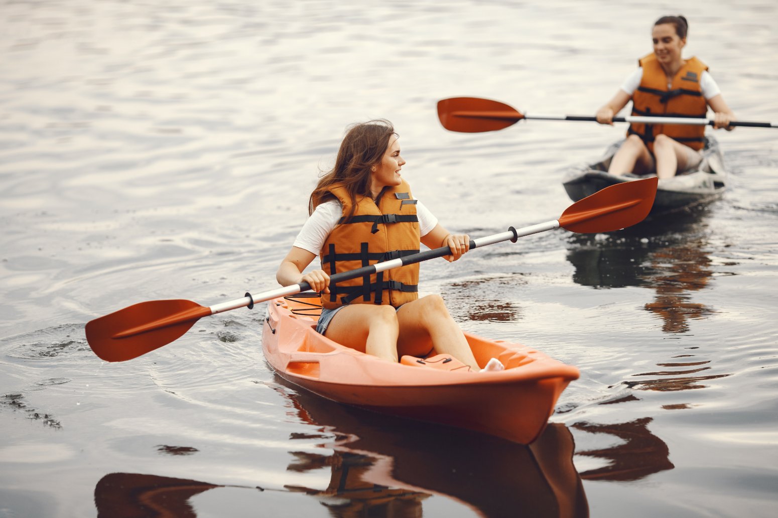 Chicas adolescentes remando en kayak, vacaciones monoparentales con adolescentes